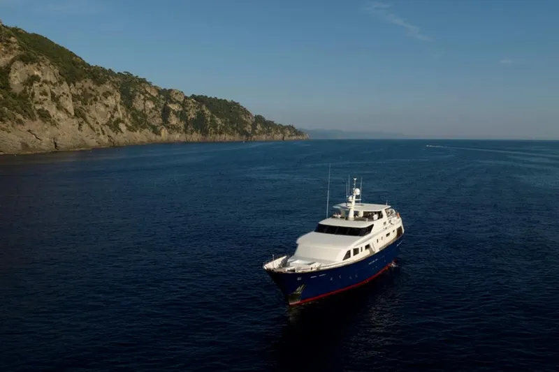 Don Ciro Yacht Photos Pics Luxurious 2002 Benetti Sail Division 105 yacht cruising near scenic coastline.