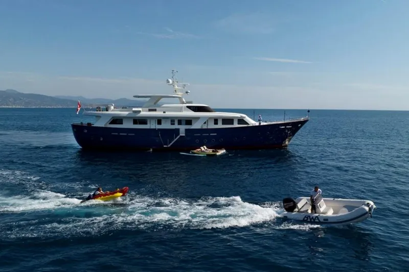 Don Ciro Yacht Photos Pics Luxury yacht Benetti Sail Division 105, 2002 model, cruising with small boats nearby.