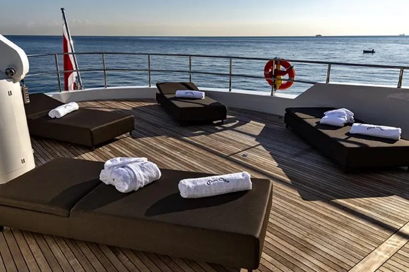 Don Ciro Yacht Photos Pics Sun loungers on Benetti Sail Division 105 yacht deck, 2002 model, overlooking the ocean.