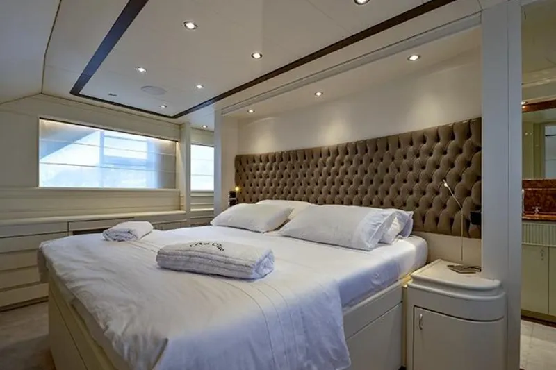 Don Ciro Yacht Photos Pics Luxurious bedroom interior on 2002 Benetti Sail Division 105 yacht, featuring elegant design and plush bedding.