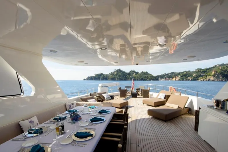 Don Ciro Yacht Photos Pics Luxurious 2002 Benetti Sail Division 105 yacht deck with elegant dining setup and scenic ocean view.