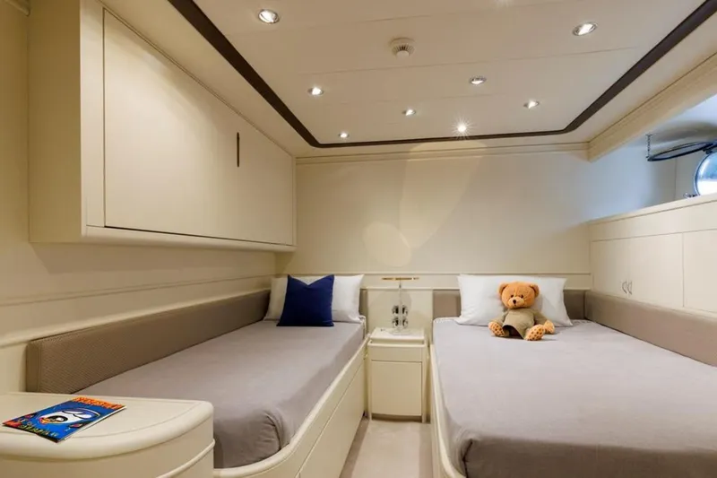 Don Ciro Yacht Photos Pics Luxurious twin cabin on 2002 Benetti Sail Division 105 yacht, featuring plush bedding and elegant decor.