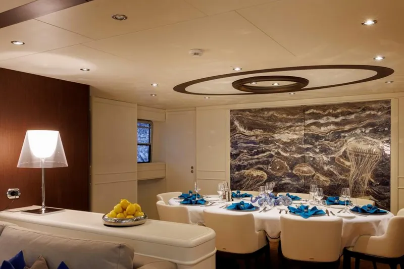 Don Ciro Yacht Photos Pics Luxurious dining area on 2002 Benetti Sail Division 105 yacht, featuring elegant decor and ambient lighting.