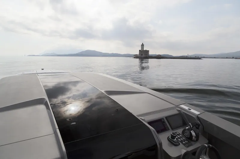  Yacht Photos Pics Luxury Maori Limo 2028 boat cruising towards a distant lighthouse on calm waters.