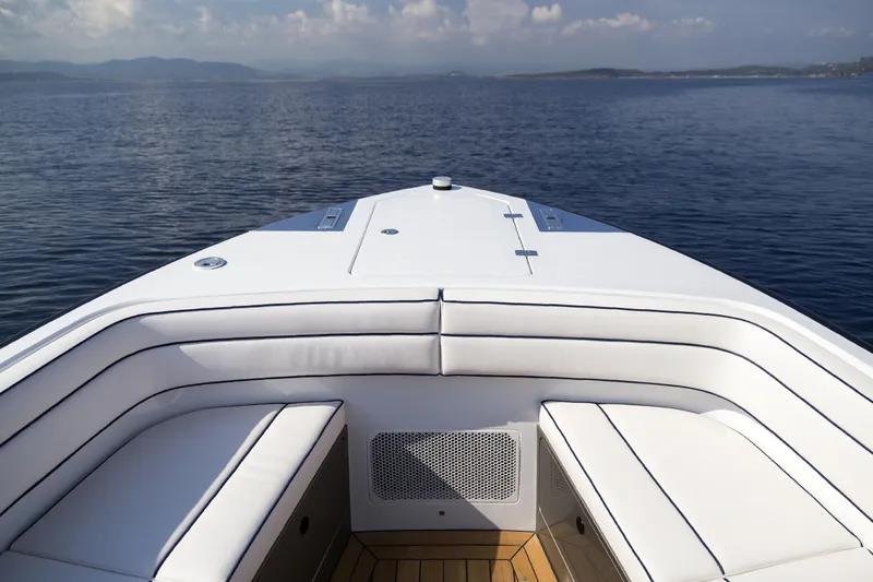  Yacht Photos Pics Front view of 2028 Maori Limo boat with white seating on calm water.