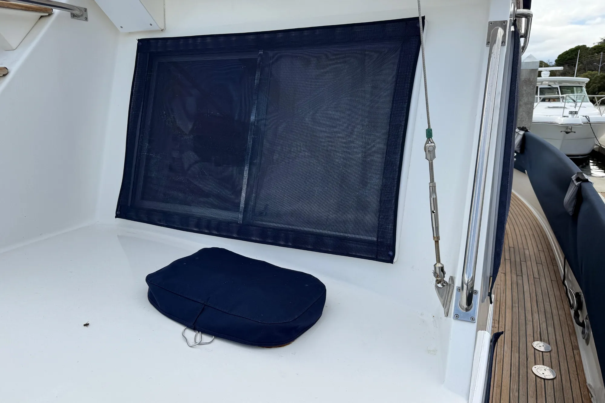 1997 Grand Banks Classic boat deck with blue cushion and window cover.