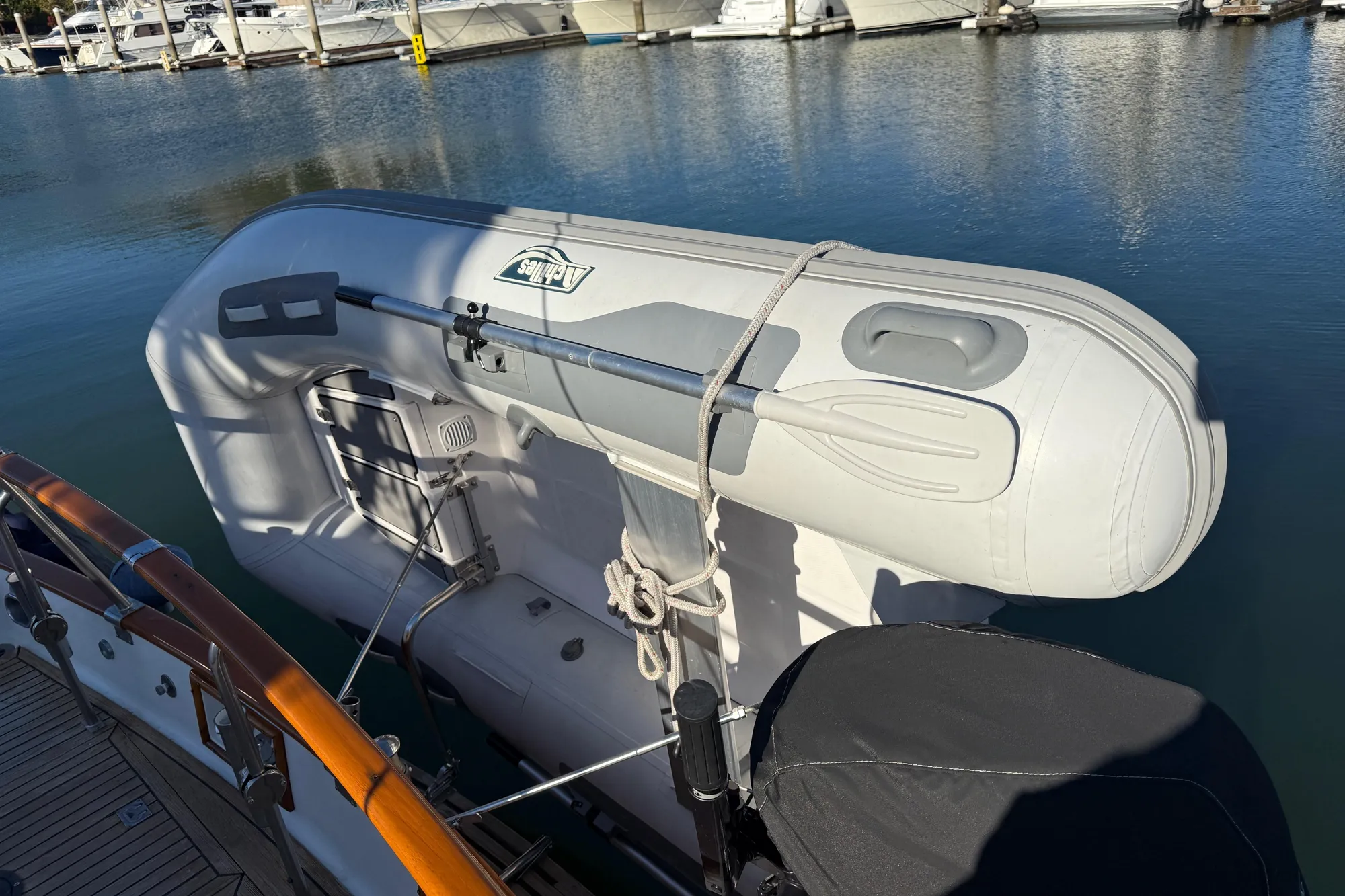 Inflatable dinghy secured on a 1997 Grand Banks Classic yacht at a marina.