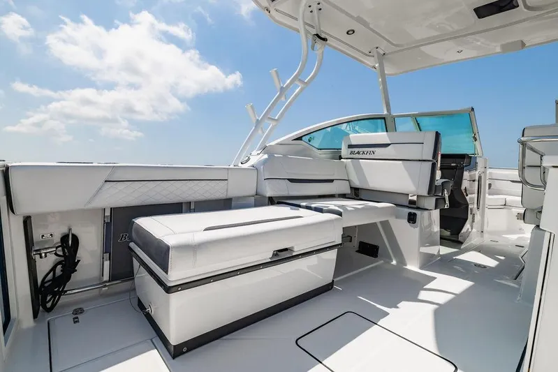  Yacht Photos Pics 2021 Blackfin 272 DC boat interior with seating and storage, under a clear blue sky.