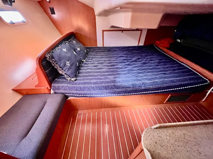 Celtic Cross Yacht Photos Pics Cozy cabin interior of 2008 Hunter 38 sailboat with blue bedding and wooden flooring.