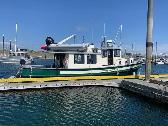 John Hunter Yacht Photos Pics Nordic Tug 37, 2000 model, docked in a marina under clear blue skies.