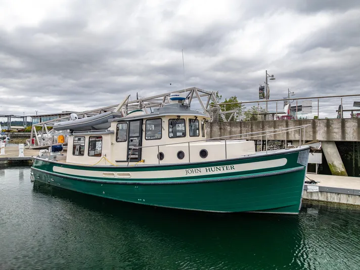 John Hunter Yacht Photos Pics Nordic Tug 37, 2000 model, docked in a marina under cloudy skies.