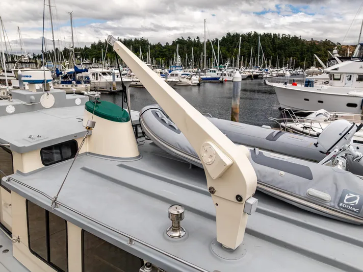 John Hunter Yacht Photos Pics Nordic Tug 37 (2000) with dinghy on deck, docked in a marina.