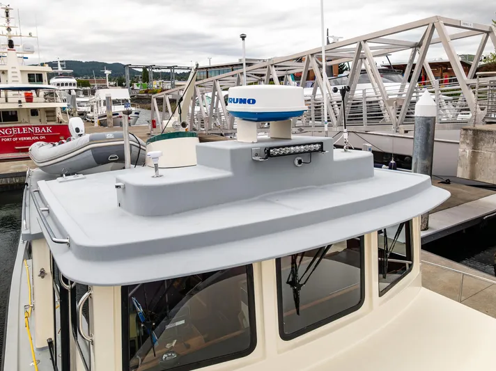 John Hunter Yacht Photos Pics Nordic Tug 37 (2000) docked at marina, featuring radar and inflatable boat.