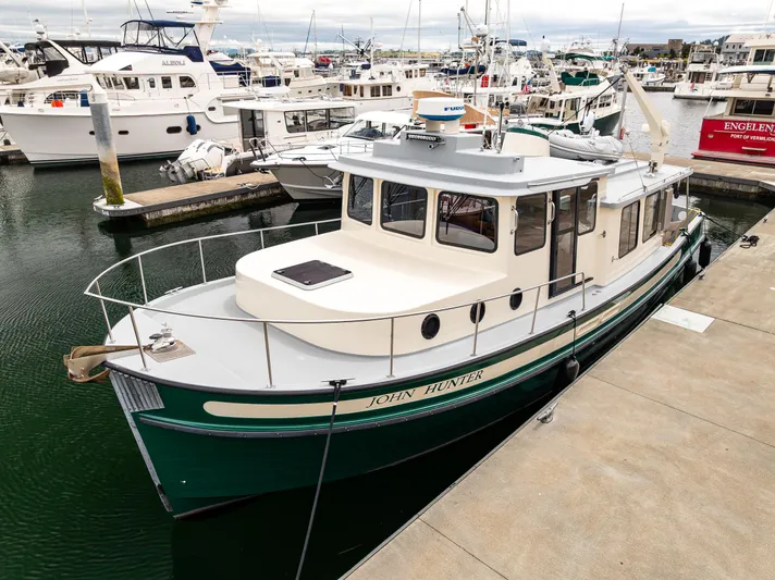 John Hunter Yacht Photos Pics 2000 Nordic Tug 37 docked at a marina, showcasing its classic design and green hull.