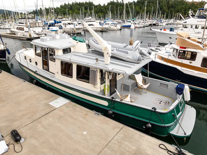 John Hunter Yacht Photos Pics 2000 Nordic Tug 37 docked in a marina, surrounded by other boats.
