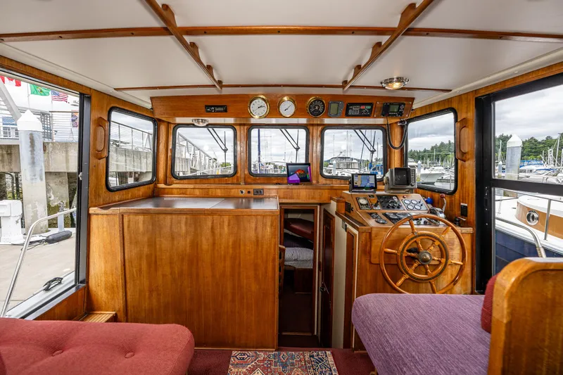 John Hunter Yacht Photos Pics Interior of a 2000 Nordic Tug 37, featuring a wooden helm and navigation equipment.