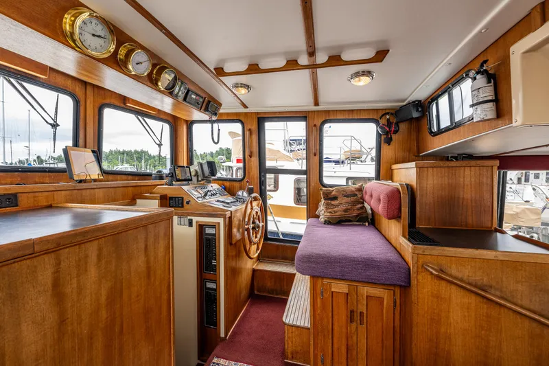 John Hunter Yacht Photos Pics Interior of a 2000 Nordic Tug 37, featuring wooden cabinetry and navigational instruments.