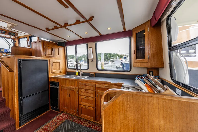 John Hunter Yacht Photos Pics Interior of 2000 Nordic Tug 37, featuring a wooden kitchen with large windows.