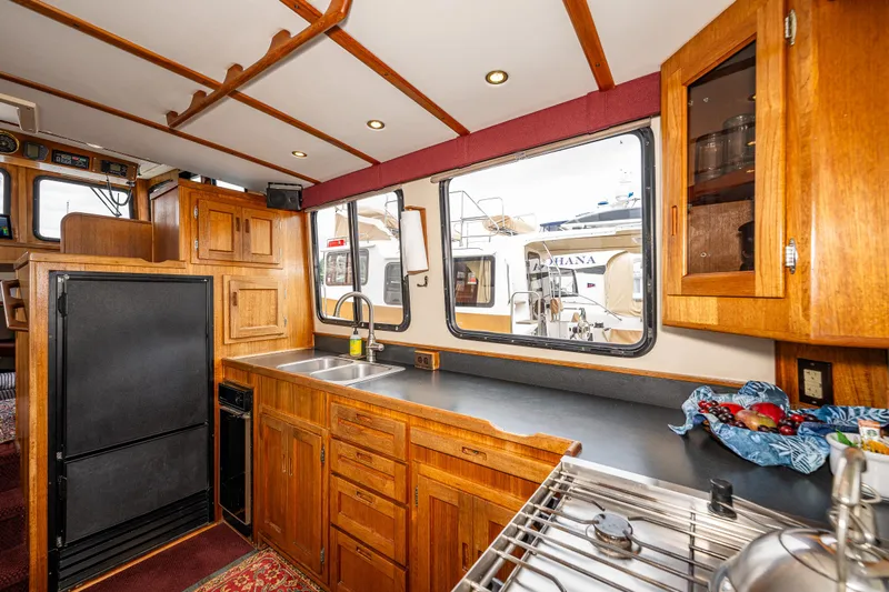 John Hunter Yacht Photos Pics Interior of 2000 Nordic Tug 37, featuring a wooden kitchen with sink and cabinets.