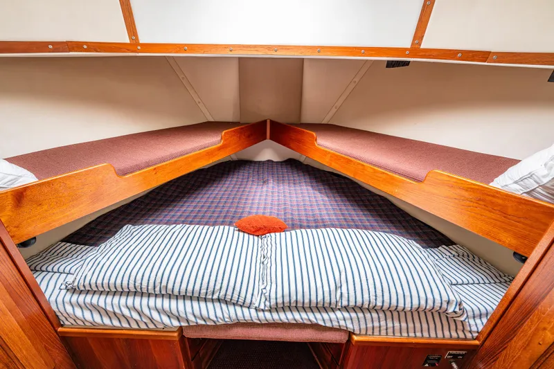 John Hunter Yacht Photos Pics Cozy cabin interior of a 2000 Nordic Tug 37 with striped bedding and wooden accents.
