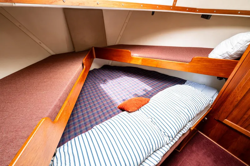 John Hunter Yacht Photos Pics Cozy cabin interior of 2000 Nordic Tug 37 with striped bedding and wooden accents.