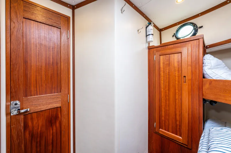 John Hunter Yacht Photos Pics Nordic Tug 37 cabin interior with wooden door and bunk beds, 2000 model.