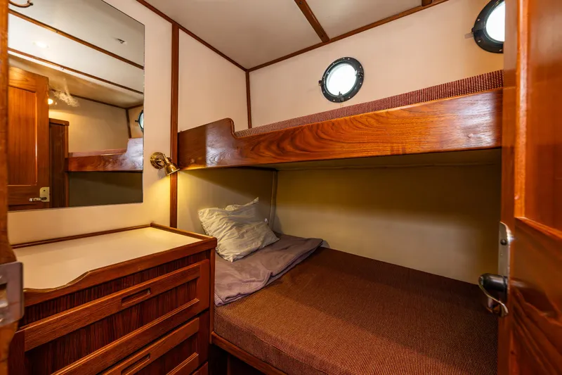John Hunter Yacht Photos Pics Cozy cabin interior of 2000 Nordic Tug 37 with wooden bunk beds and porthole windows.