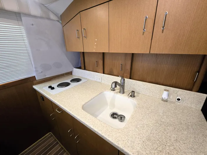 Relentless Yacht Photos Pics 2001 Ocean Yachts 43 Super Sport kitchen with sink, stove, and wooden cabinets.