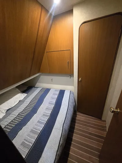 Relentless Yacht Photos Pics 2001 Ocean Yachts 43 Super Sport cabin with bed, wooden walls, and striped bedding.