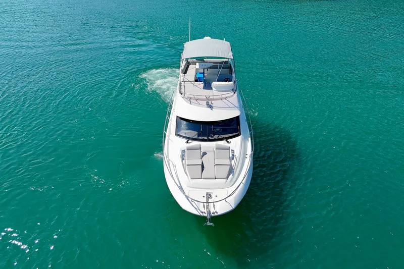  Yacht Photos Pics 2023 Prestige 460 Flybridge yacht cruising on turquoise water.