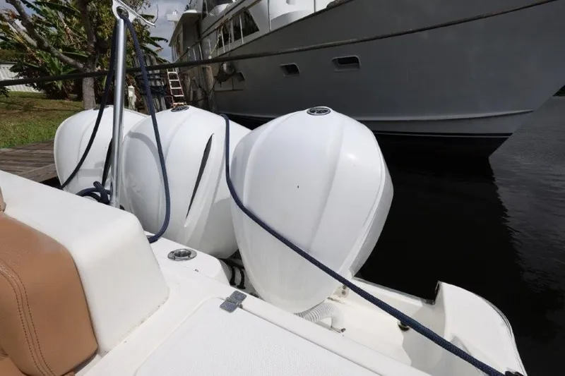 Bada Bing Yacht Photos Pics 2020 HCB 39 Speciale boat with triple outboard engines docked near a yacht.