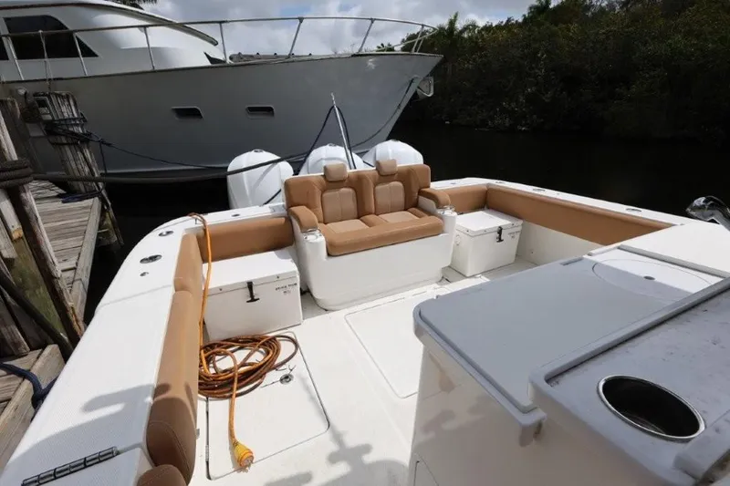 Bada Bing Yacht Photos Pics 2020 HCB 39 Speciale boat with tan seating, docked near a larger vessel.