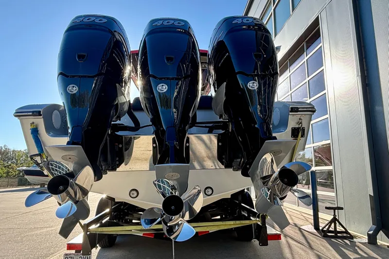  Yacht Photos Pics Triple outboard motors on a 2021 Fountain 38 SC boat, parked near a building.