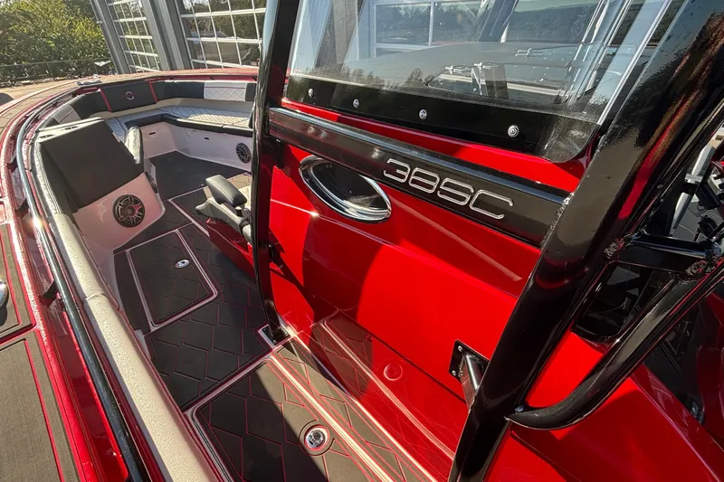 Yacht Photos Pics 2021 Fountain 38 SC boat interior with red and black design, featuring seating and speakers.