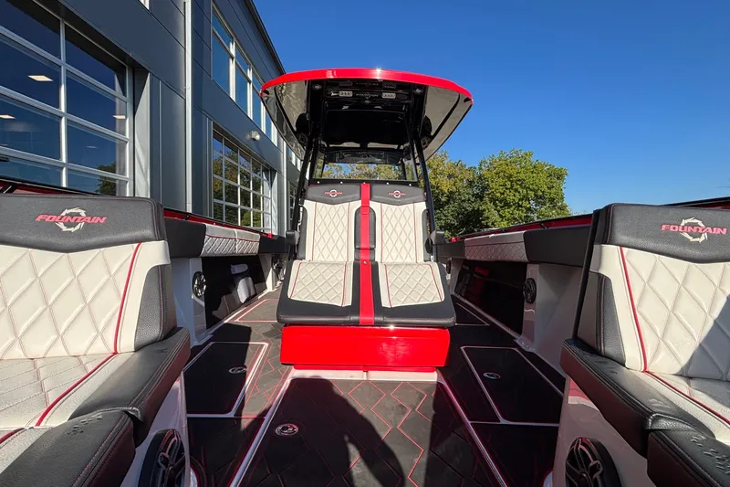  Yacht Photos Pics 2021 Fountain 38 SC boat interior with red and white seating, docked near a building.