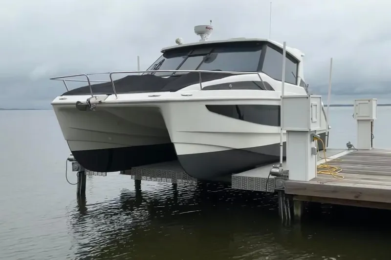  Yacht Photos Pics Aquila 36 Sport 2022 catamaran docked on a lift by the water.
