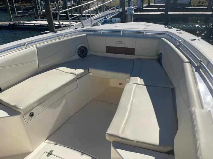  Yacht Photos Pics 2023 Cobia 320 CC boat interior with cushioned seating and dock view.