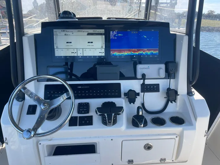 Yacht Photos Pics Cobia 320 CC 2023 helm with Garmin displays and controls on a sunny day.