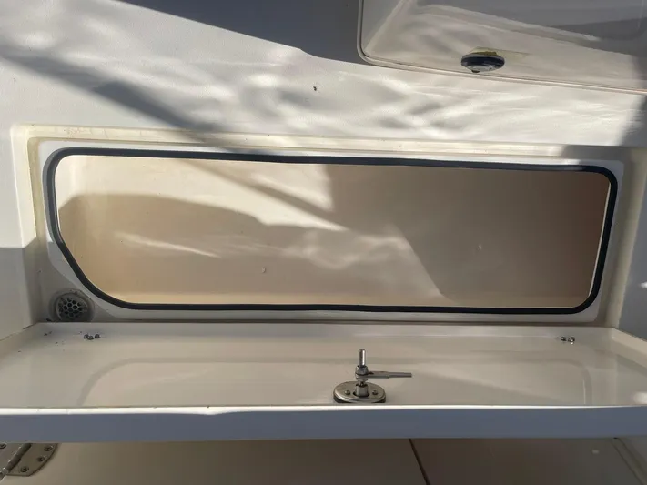  Yacht Photos Pics 2023 Cobia 320 CC boat storage compartment with latch, interior view.