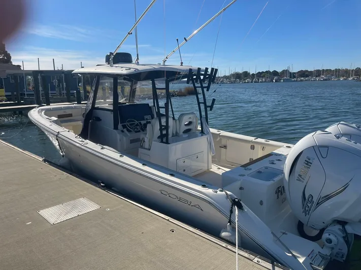  Yacht Photos Pics 2023 Cobia 320 CC boat docked by the water on a sunny day.