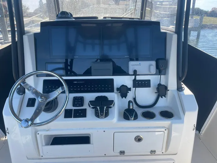  Yacht Photos Pics 2023 Cobia 320 CC boat dashboard with Garmin navigation system and steering wheel.