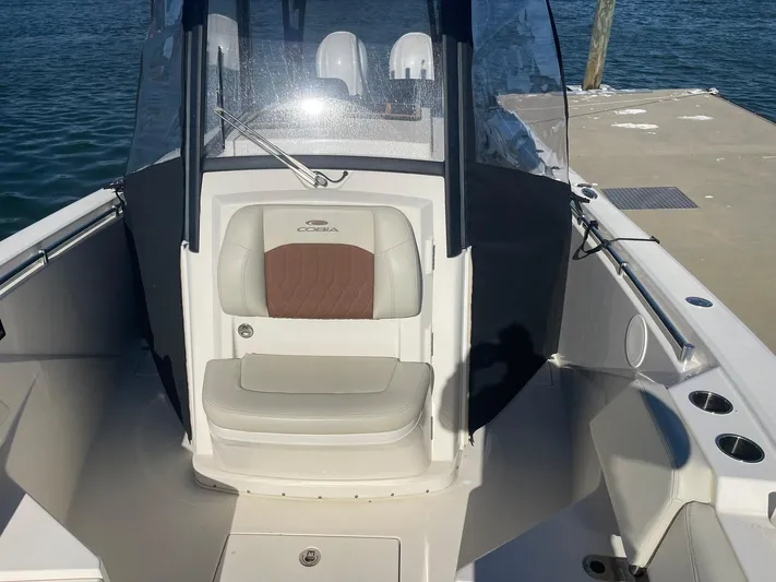  Yacht Photos Pics 2023 Cobia 320 CC boat interior with seating and windshield at dock.