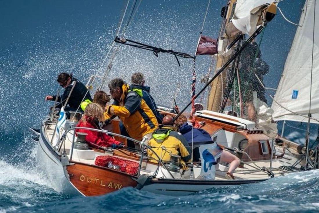 Sailing yacht "Outlaw" by Souters of Cowes, 1963, navigating rough seas with crew.