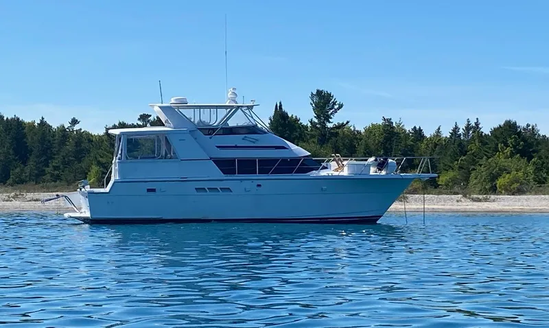  Yacht Photos Pics 1994 Hatteras 48 Cockpit MY yacht anchored near a forested shoreline.