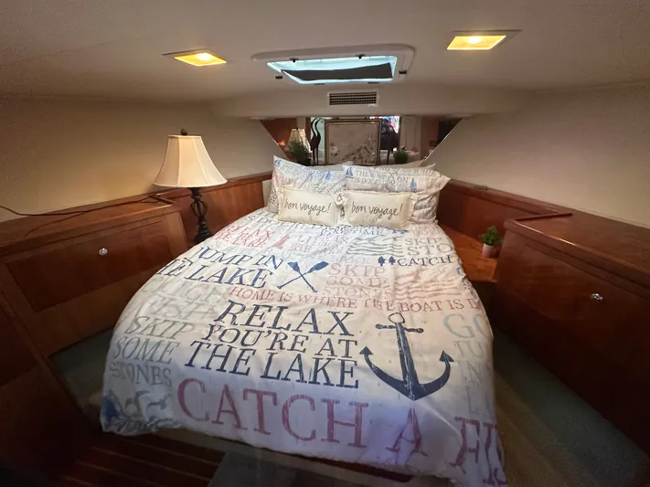  Yacht Photos Pics Cozy bedroom in 1994 Hatteras 48 Cockpit MY yacht with nautical-themed bedding.