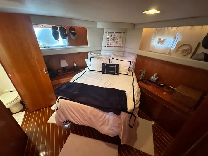 Yacht Photos Pics Cozy bedroom interior of 1994 Hatteras 48 Cockpit MY yacht with wooden accents and nautical decor.