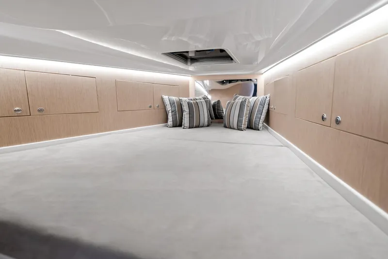  Yacht Photos Pics Luxurious interior cabin of 2021 Magazzu TARGA 45 with striped pillows and sleek wood paneling.