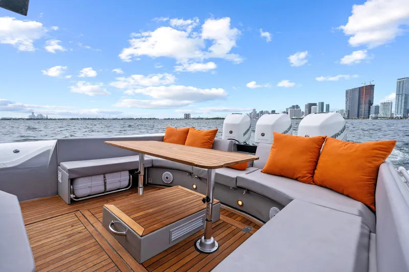  Yacht Photos Pics Luxurious 2021 Magazzu TARGA 45 yacht with elegant seating, orange cushions, and city skyline view.