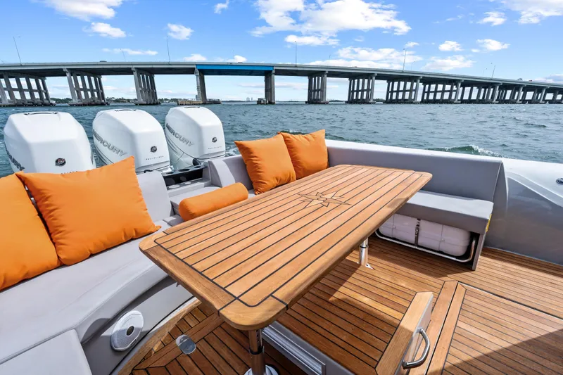  Yacht Photos Pics Luxurious 2021 Magazzu TARGA 45 yacht with wooden deck, orange cushions, and scenic bridge view.
