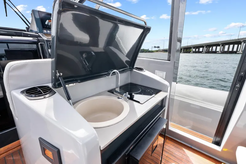  Yacht Photos Pics Outdoor kitchenette on 2021 Magazzu TARGA 45 yacht with sink and stove, near water.